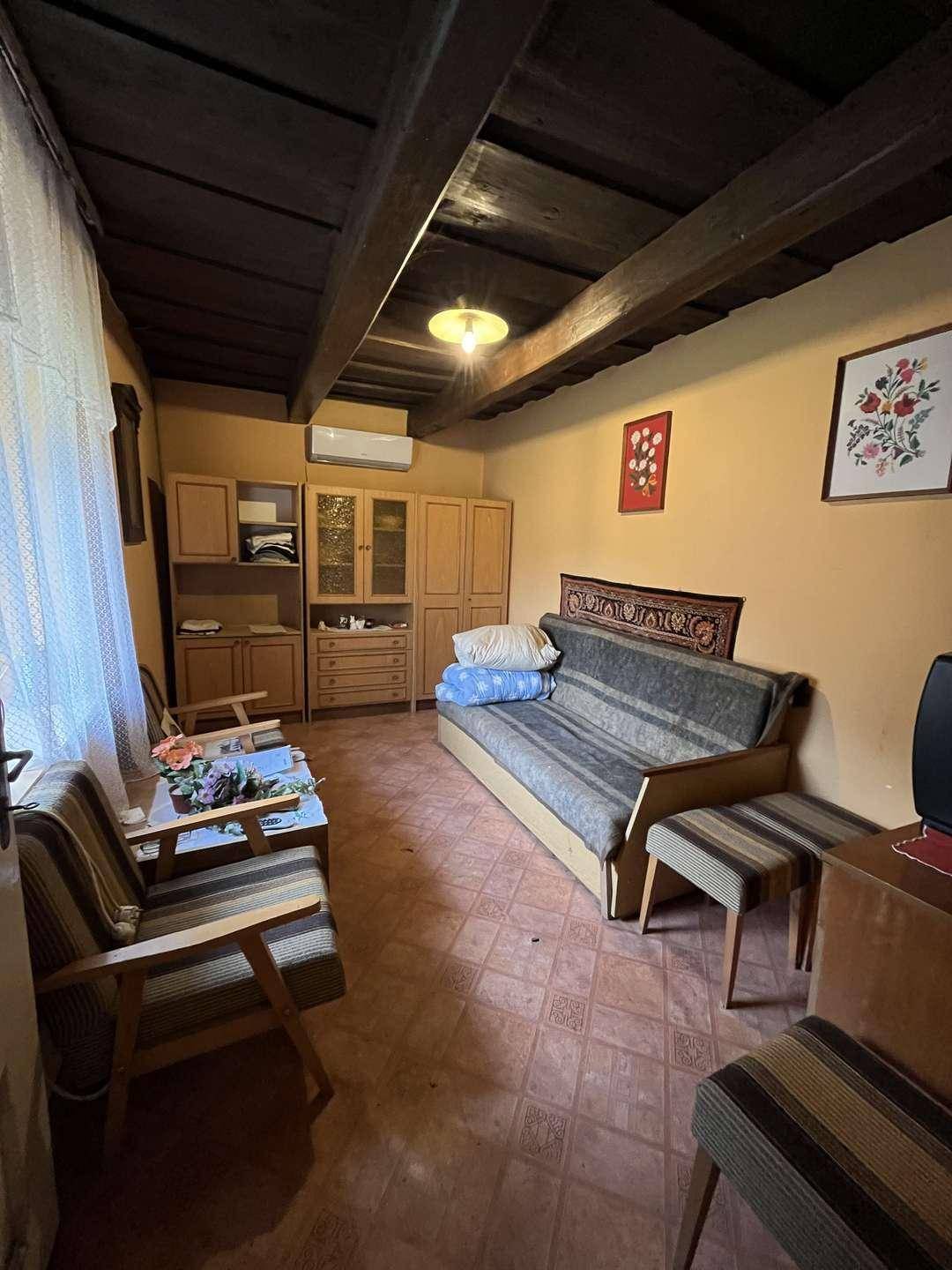 Schlafzimmer mit traditionellen Möbeln, Holzbalkendecke und Klimaanlage.