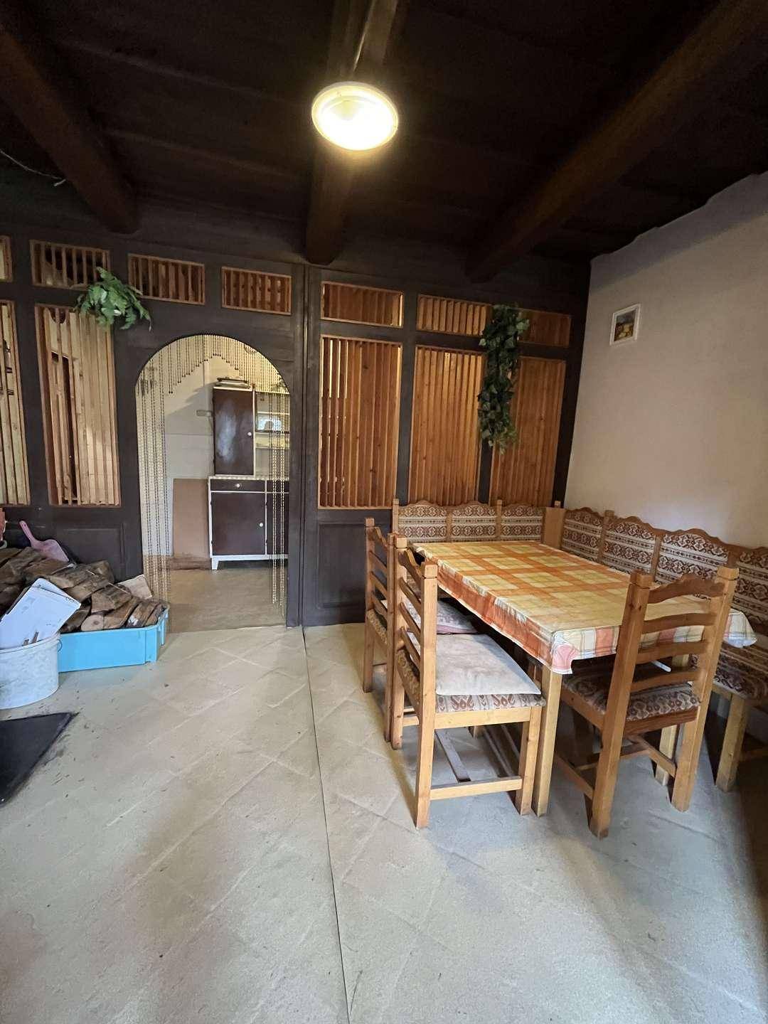 Essbereich mit Holztisch, Bänken und Zugang zu einem weiteren Raum.