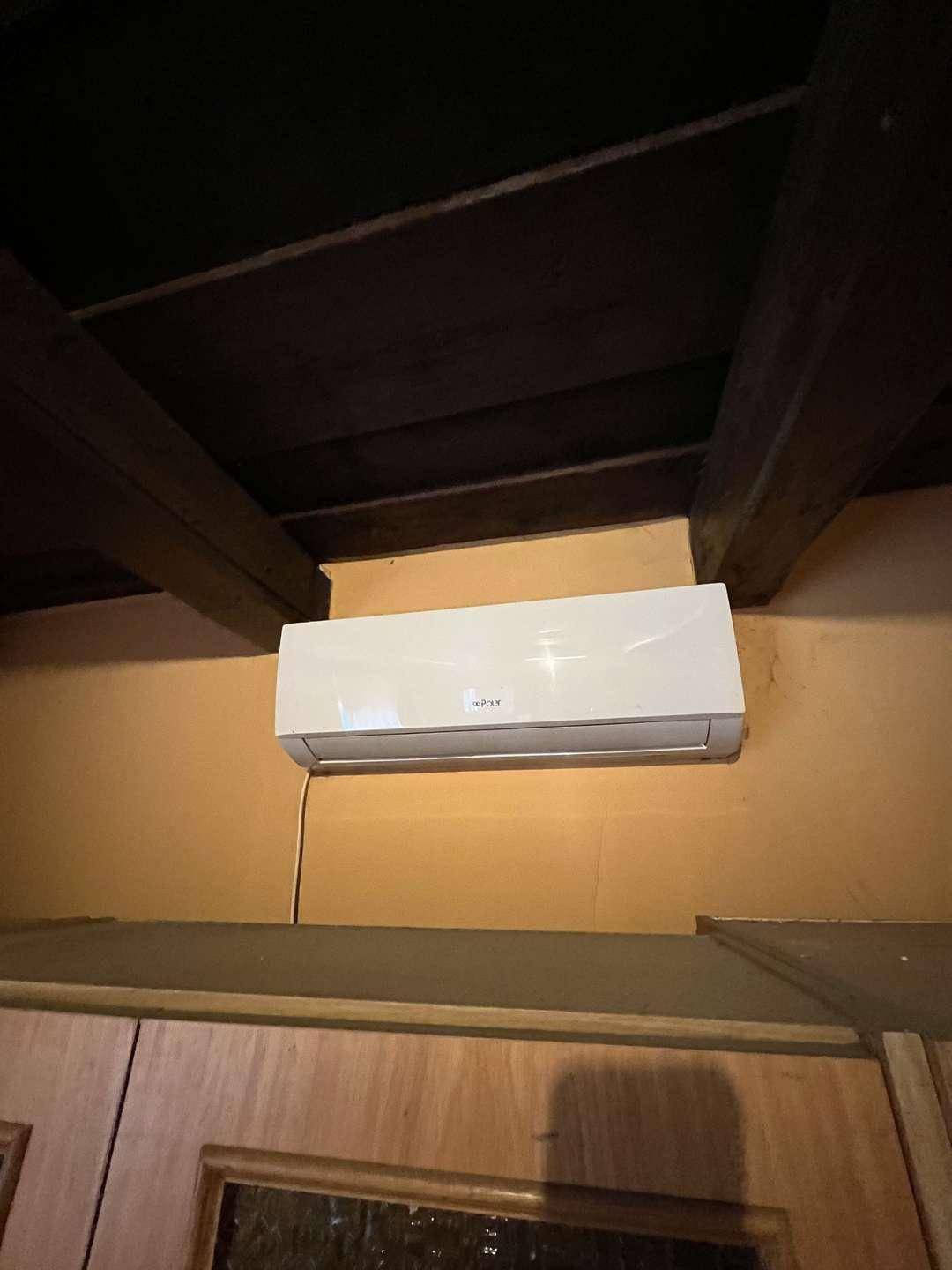 Nahaufnahme einer Klimaanlage unter einer Holzbalkendecke.
