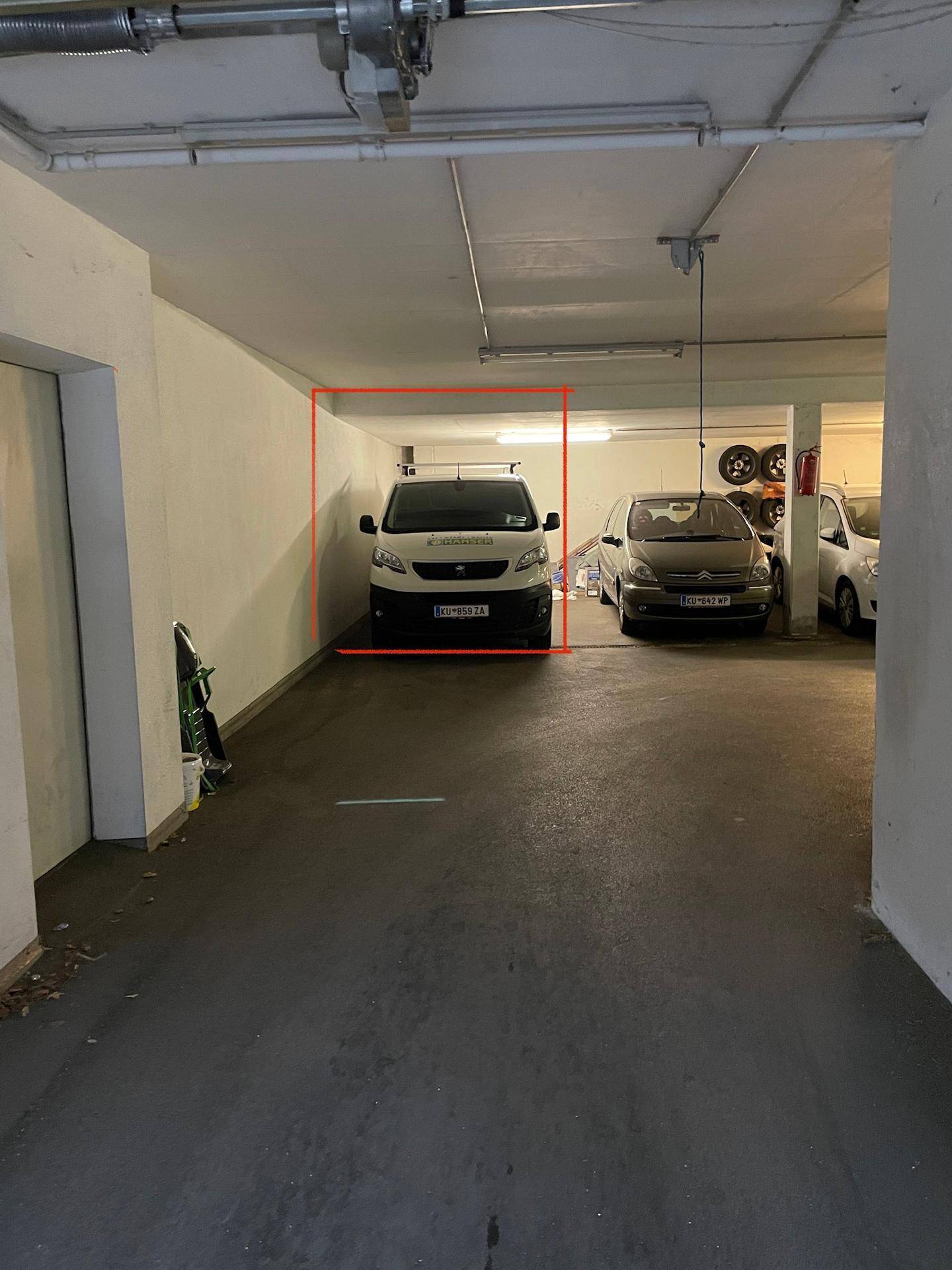 Tiefgarage mit mehreren Stellplätzen und einem geparkten Lieferwagen, gut beleuchtet.