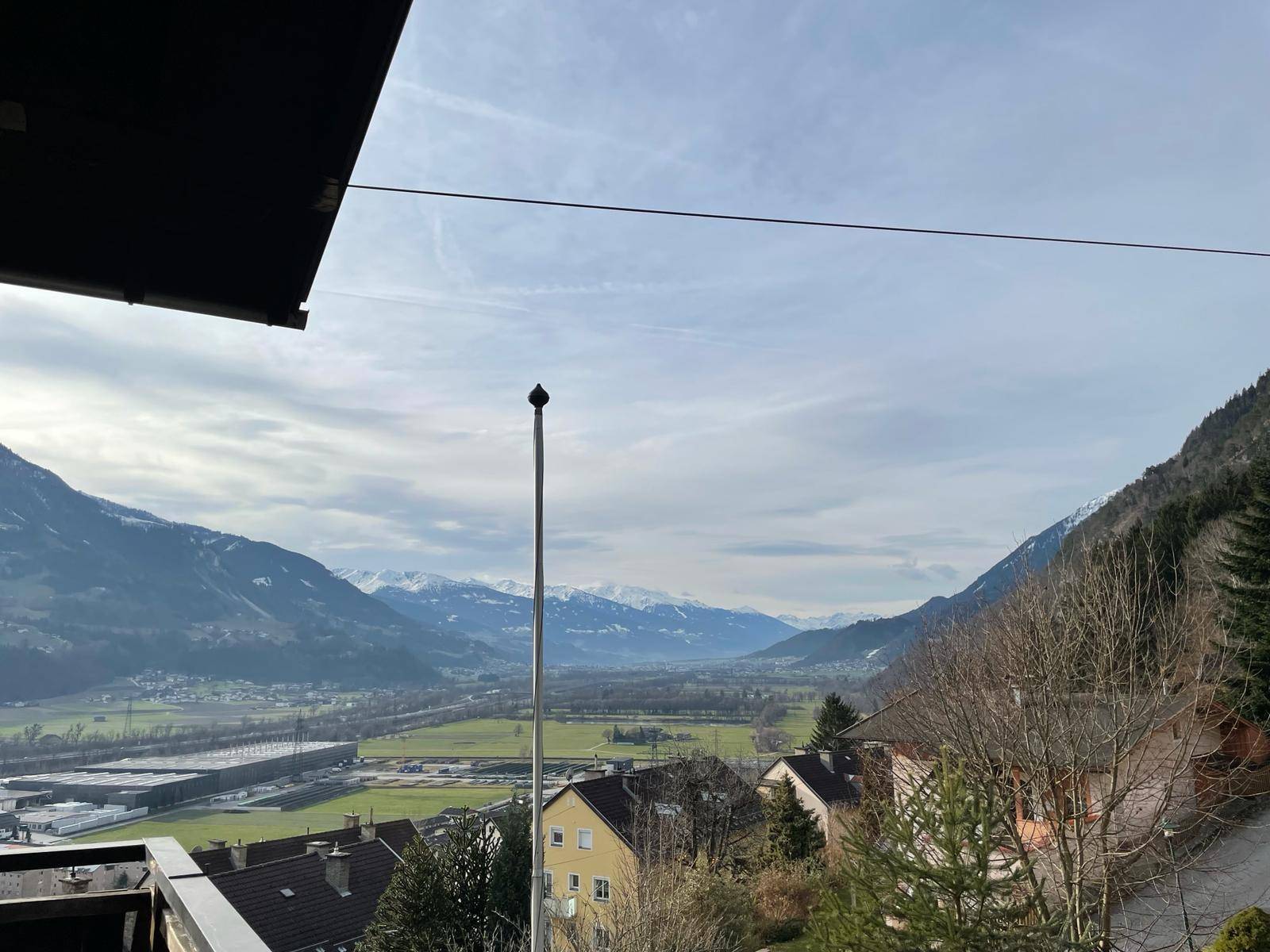Weitläufiger Panoramablick über das Tal mit Bergen und umliegenden Häusern.