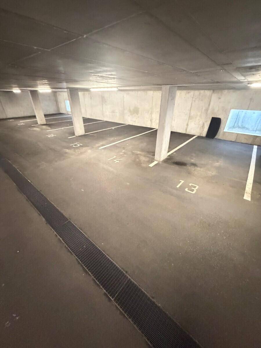 Geräumige Tiefgarage mit nummerierten Stellplätzen, Betonstützen und guter Beleuchtung.