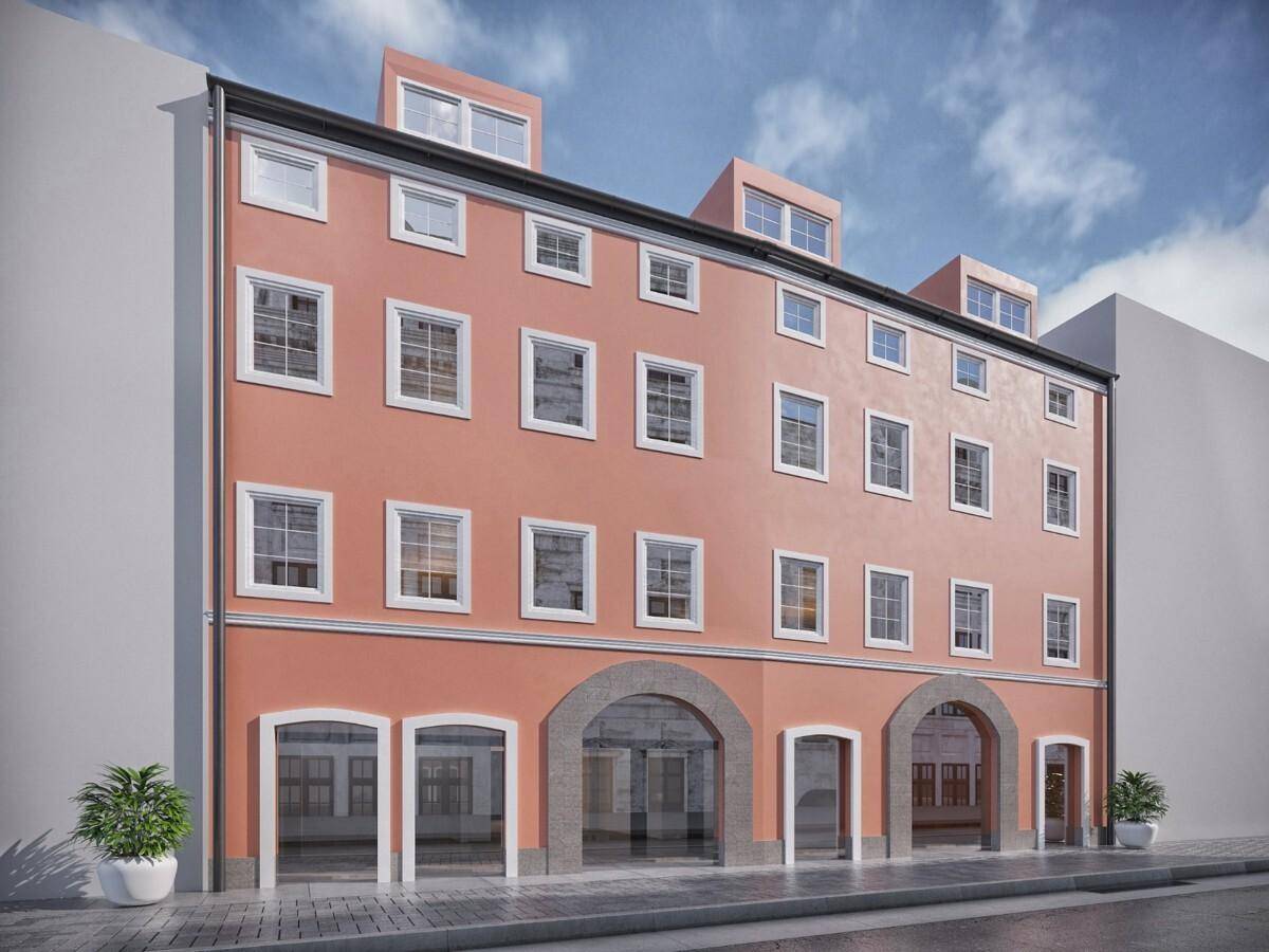Historische Fassade eines sanierten Gebäudes mit großen Fenstern und modernen Dachgauben.