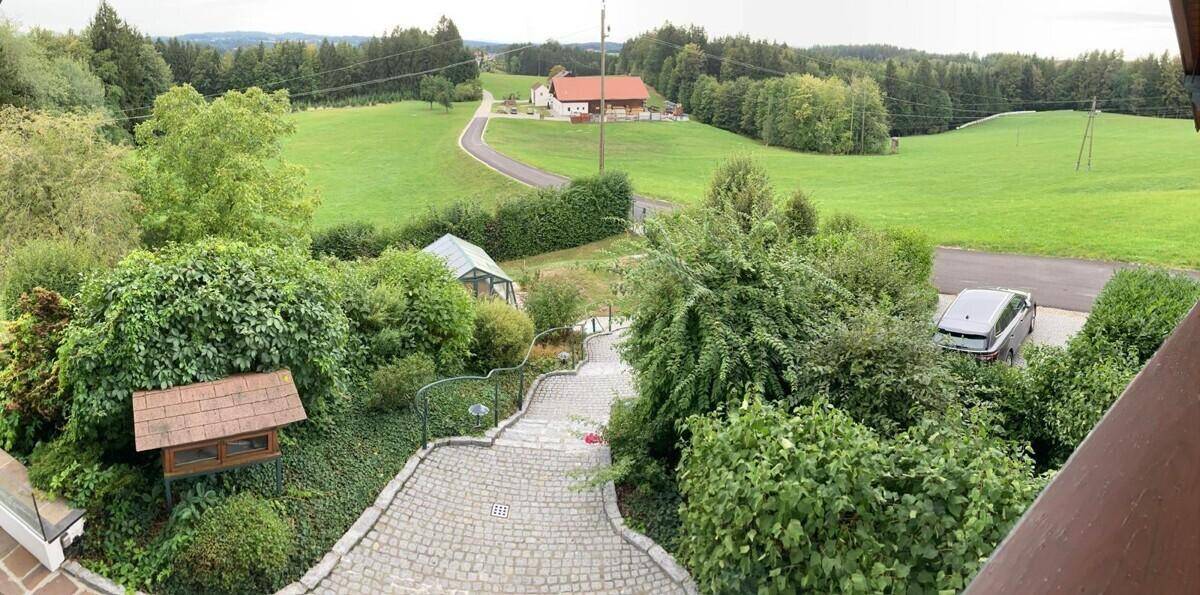 Weitläufiger Blick auf das Anwesen mit gepflasterter Auffahrt und ländlicher Umgebung.