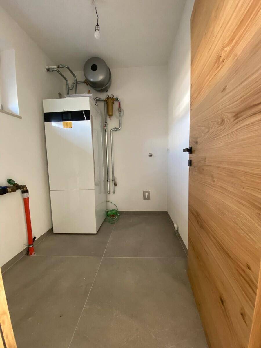 Hauswirtschaftsraum mit Heizungsanlage, Leitungen und Fenster.