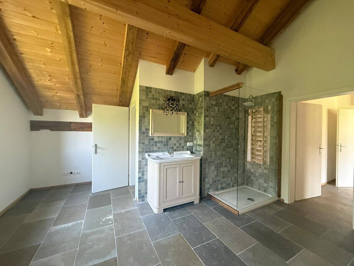 Modernes Badezimmer mit Holzbalkendecke, Schieferboden, Einzelwaschbecken und begehbarer Dusche.