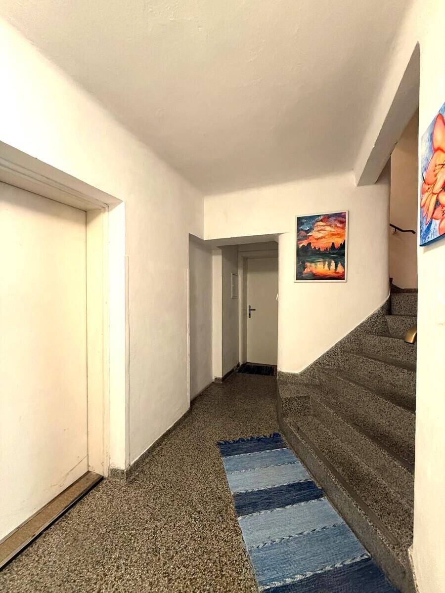 Eingangsbereich mit Treppe und Teppichläufer, der zu den oberen Etagen führt.