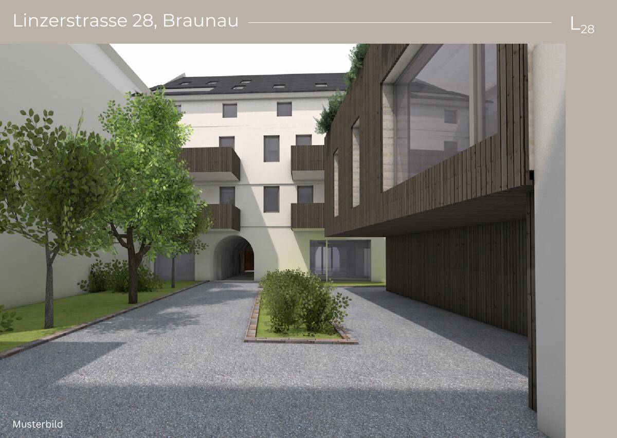 Innenhof eines modernen Wohnkomplexes mit Bäumen und begrünten Bereichen.