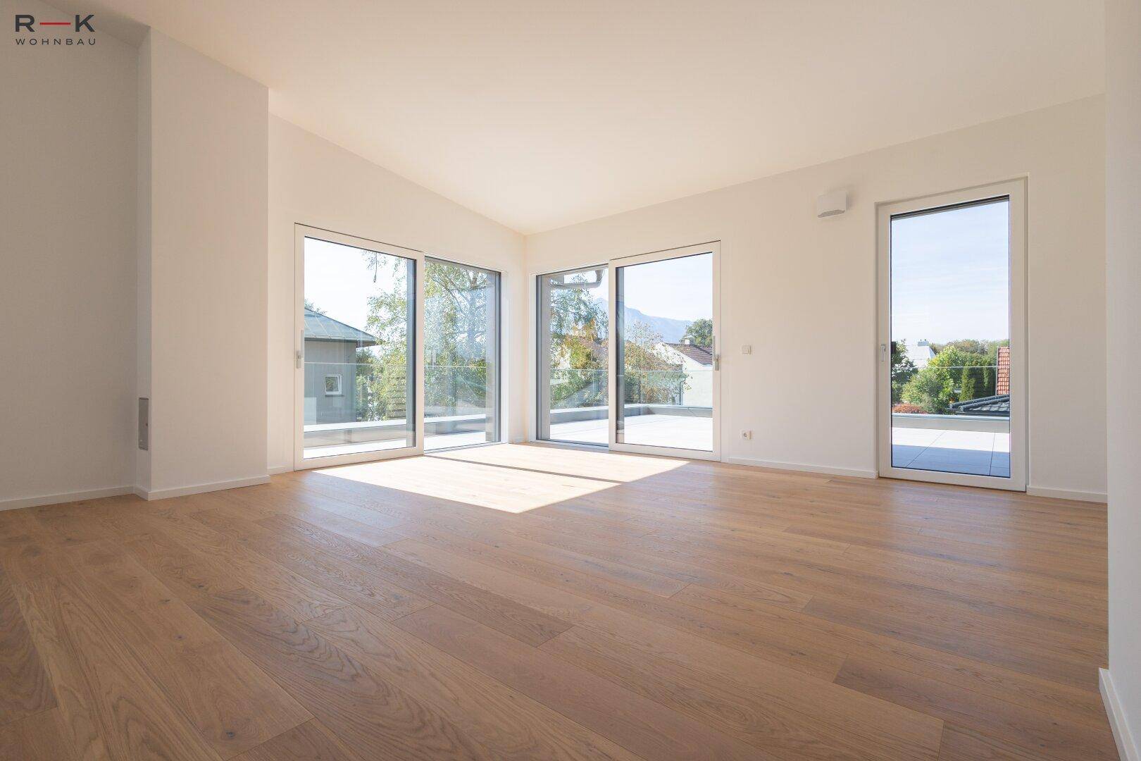 Heller Wohnraum mit Eichenparkett und großen Schiebetüren, die viel Tageslicht hereinlassen.