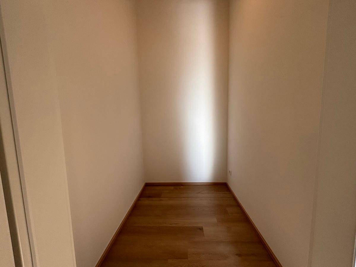 Kleiner, leerer Raum mit Parkettboden, ideal als Abstellraum oder begehbarer Kleiderschrank.