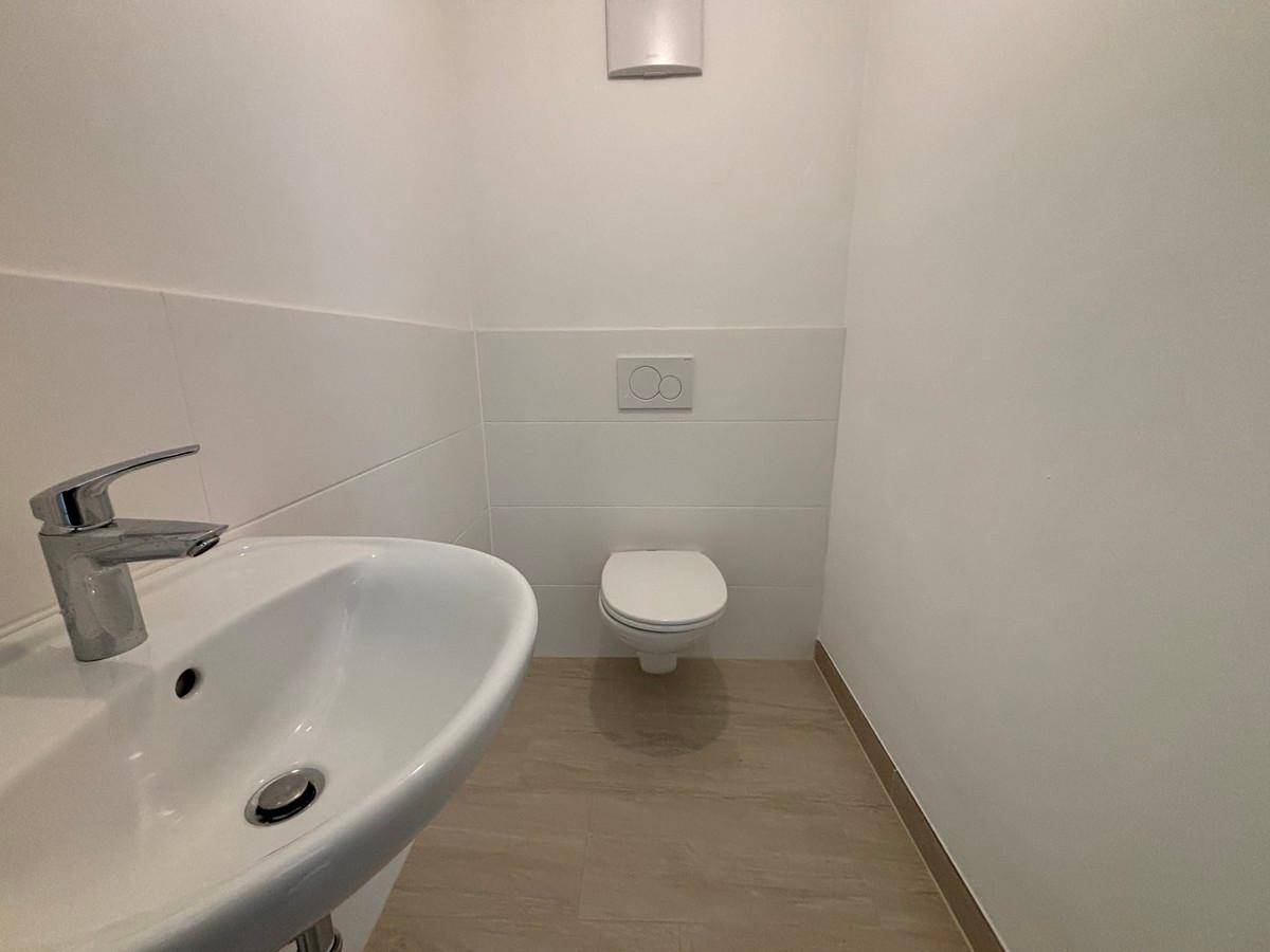 Kleines Gäste-WC mit wandhängendem WC und modernem Waschbecken.