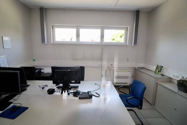 Büroarbeitsplatz mit Computer, Telefon und Fensterfront.