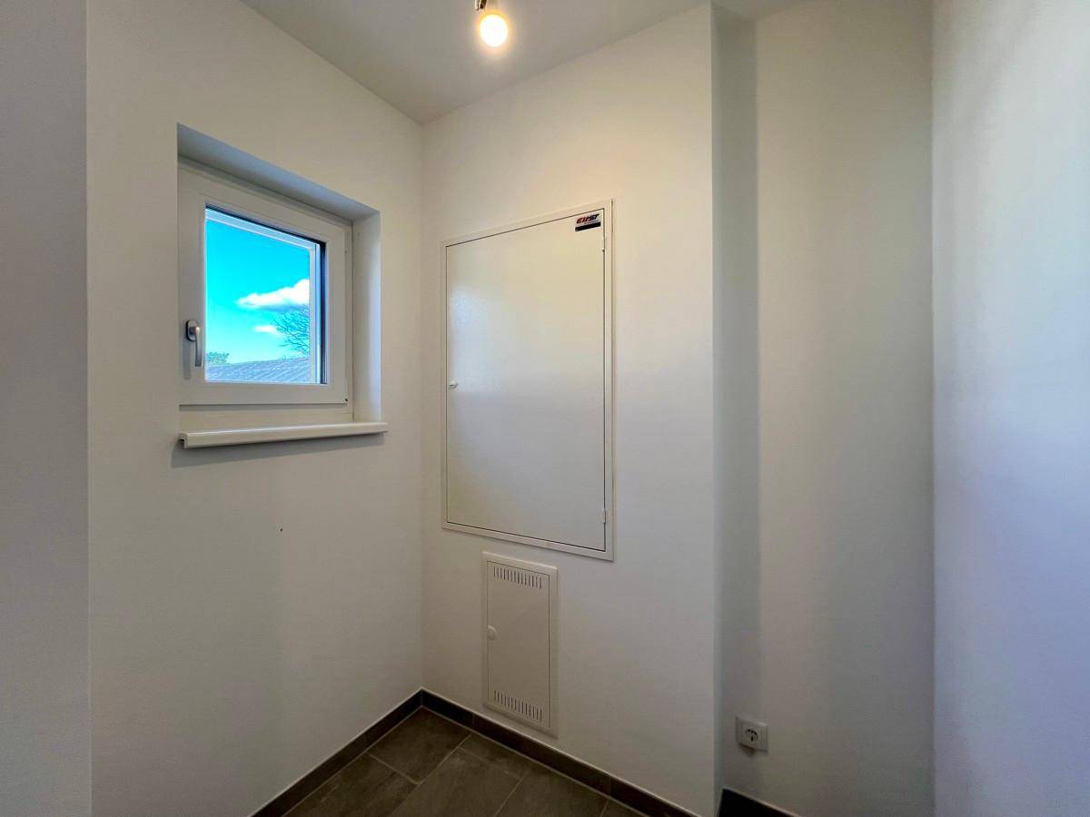 Kleiner Hauswirtschaftsraum mit Fenster, Fliesenboden und Zugang zu den Elektroinstallationen.