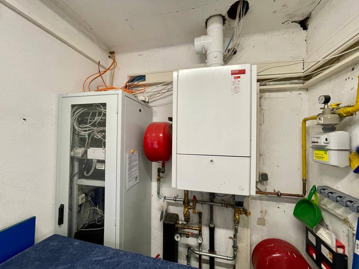 Technikraum mit Heizungsanlage, Warmwasserspeicher und Netzwerkverteiler.