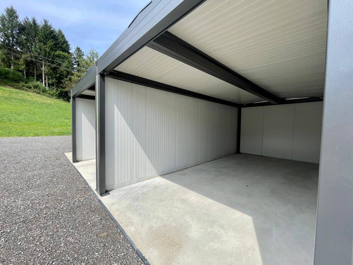 Neue Carports mit Betonboden und Metallkonstruktion bieten geschützte Parkmöglichkeiten.