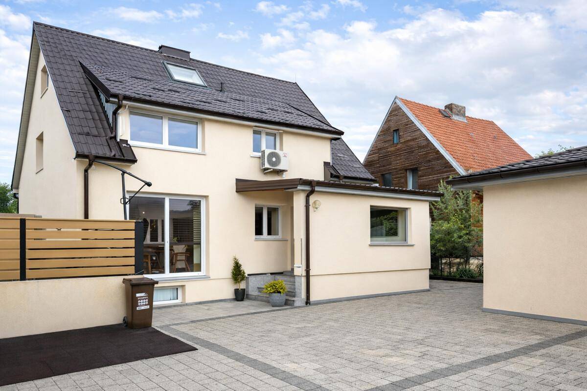 Rückansicht des Hauses mit gepflastertem Hof, Terrasse und Zugang zum Garten.