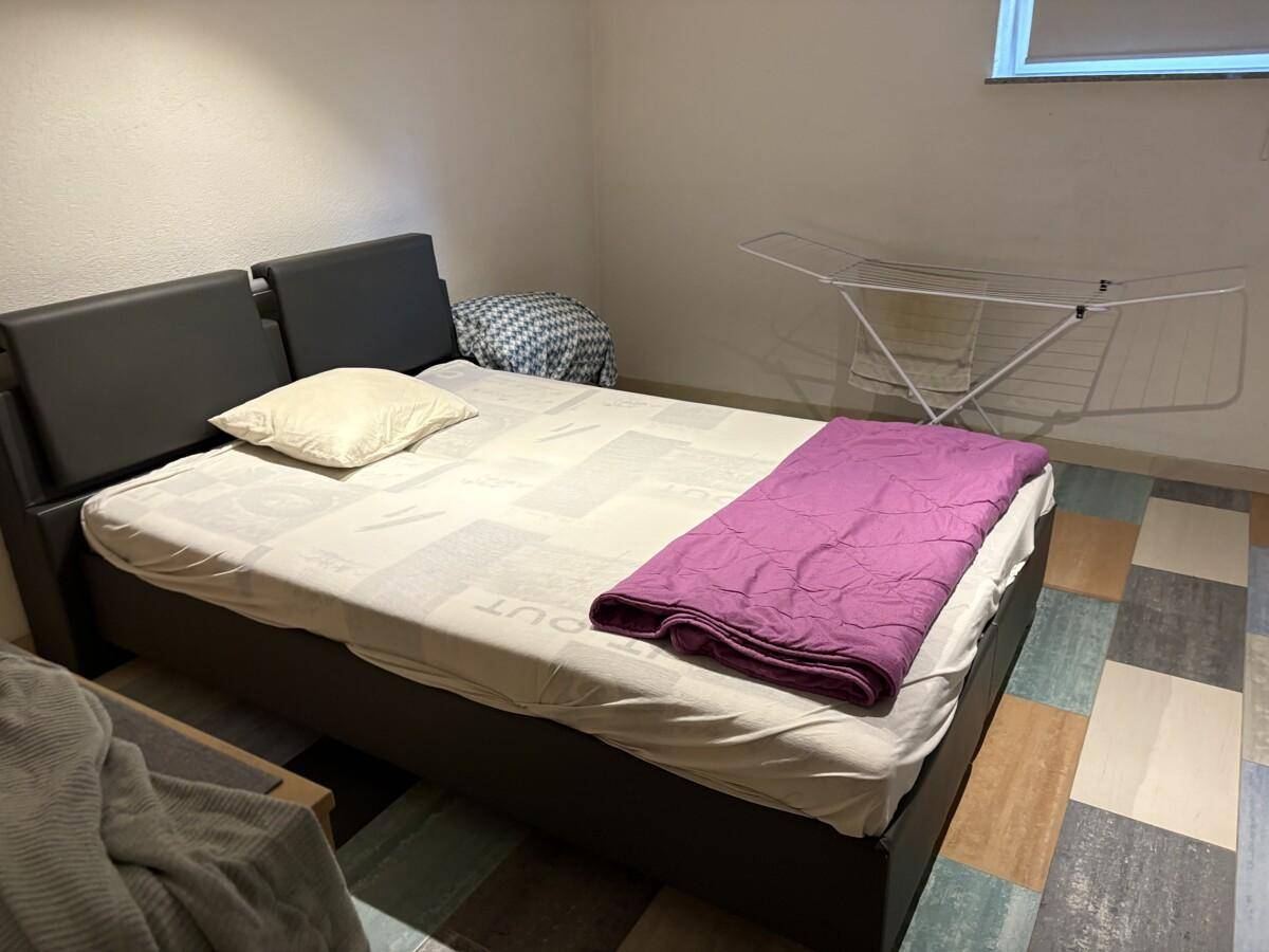 Schlafzimmer im Untergeschoss mit Doppelbett und praktischem Wäscheständer.