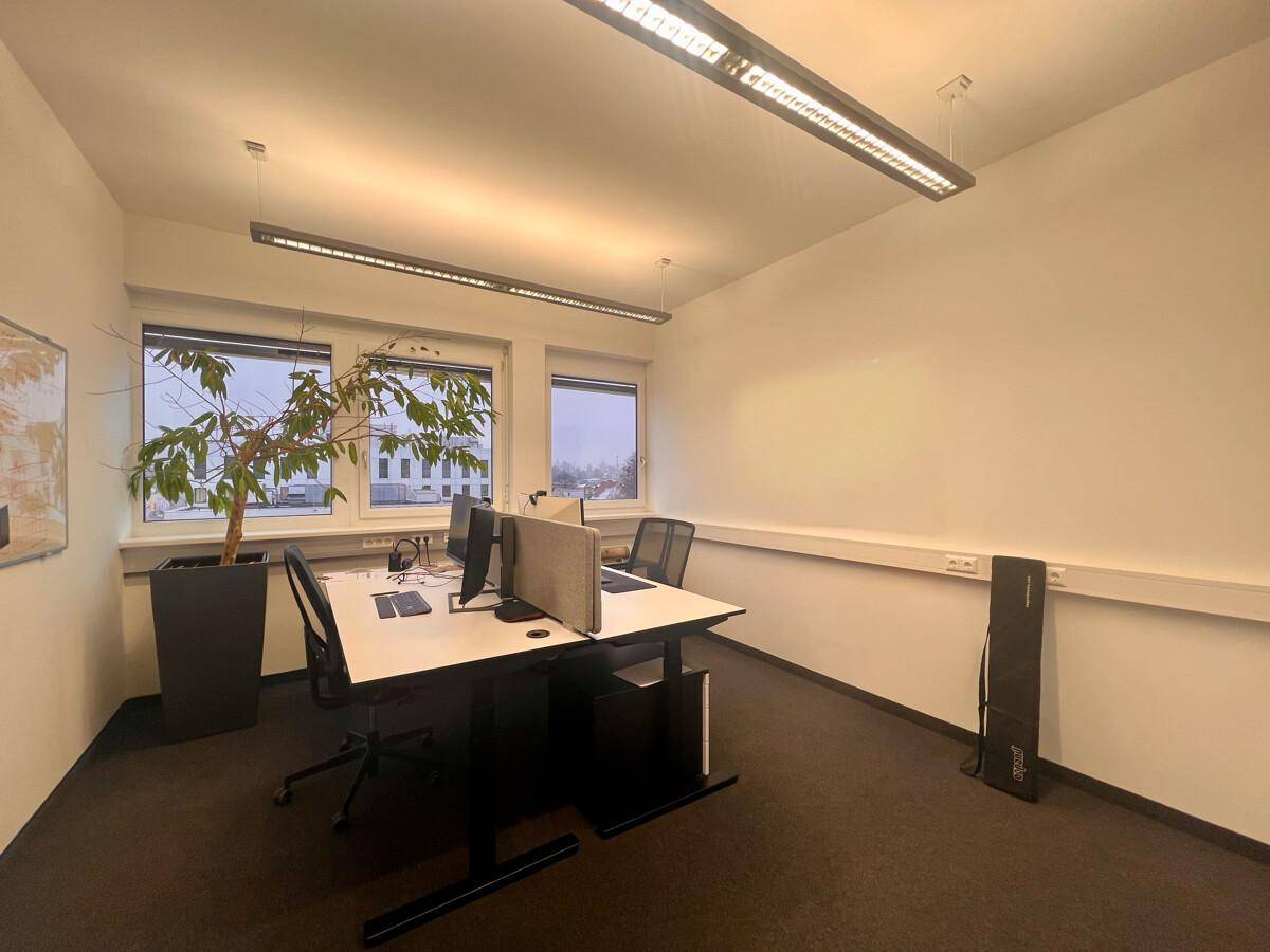 Büroraum mit zwei Arbeitsplätzen, Schreibtischen und ergonomischen Stühlen, mit Blick auf die Umgebung.