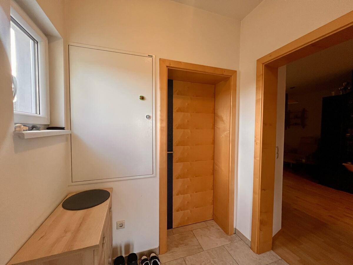 Eingangsbereich mit Fliesenboden und Holztüren in hellem Design.
