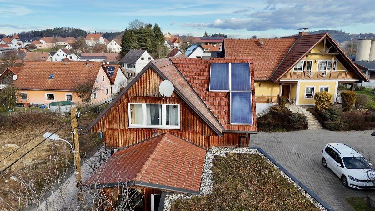 Luftaufnahme des Hauses mit Photovoltaikanlage und umliegender Bebauung.