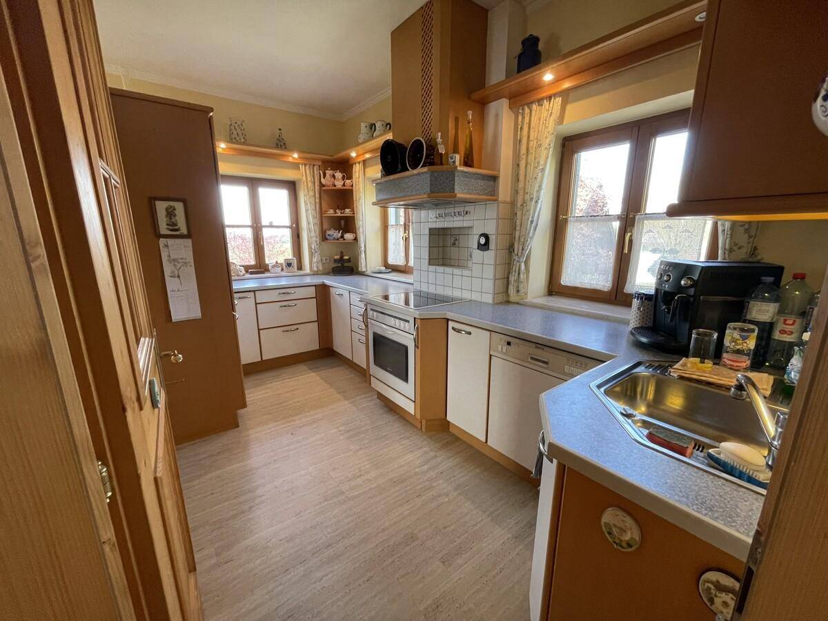 Funktionale Küche im Landhausstil mit Holzschränken, Fliesen und Fensterblick.