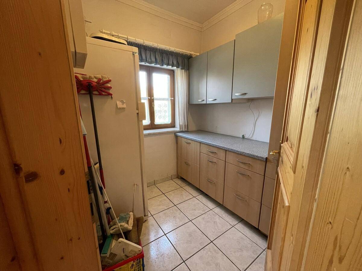 Praktischer Abstellraum mit Regalen, Fenster und Fliesenboden.