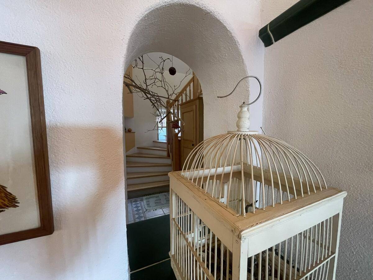 Heller Flur mit gewölbtem Durchgang und Treppe zum Obergeschoss.