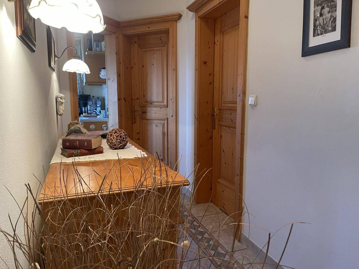 Flur mit Fliesenboden, Holzmöbeln und traditionellen Holztüren.