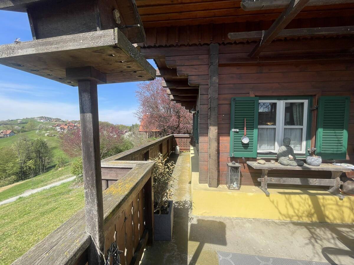 Langer Balkon mit Holzgeländer und weitem Blick über die Landschaft.