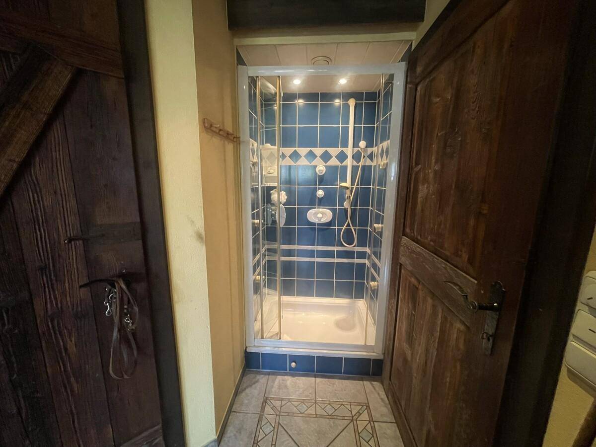 Kleines Badezimmer mit Duschkabine und blauen Fliesen.