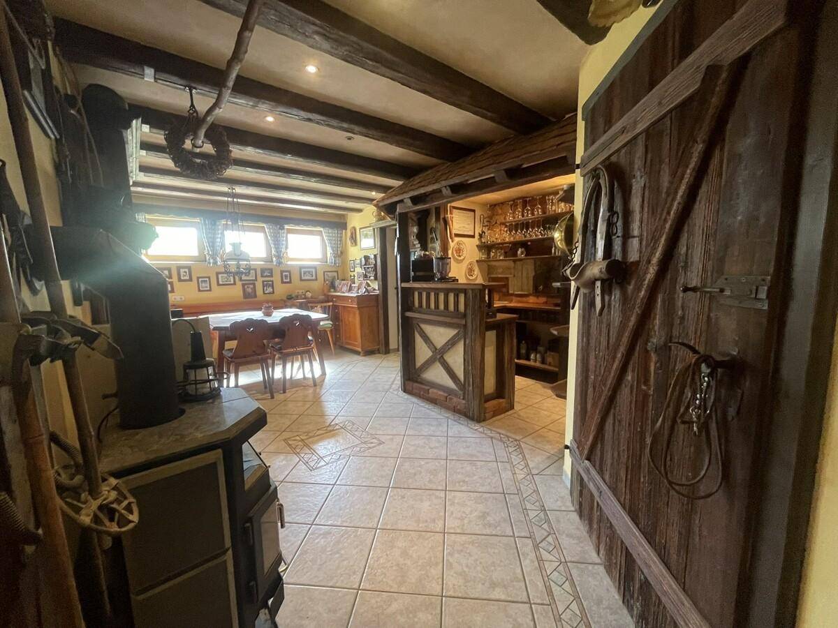 Rustikaler Wohnbereich mit Bar, Holzbalken und traditionellen Möbeln.
