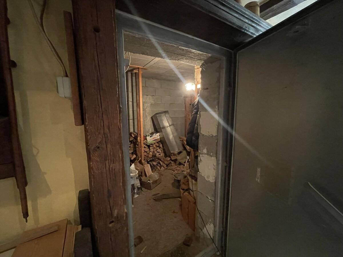 Lagerraum im Keller mit gestapeltem Brennholz und Baumaterialien.