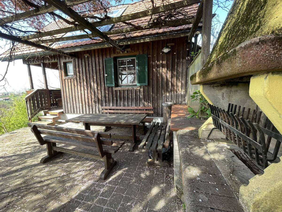 Außenbereich mit Grillplatz, Holzbänken und Tisch, ideal für gesellige Abende.