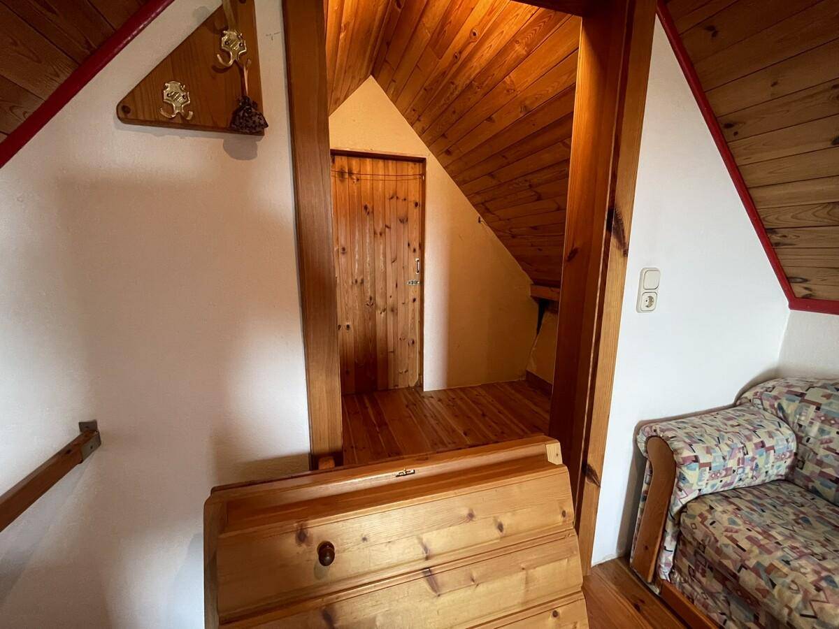 Dachbodenbereich mit Holzboden und Zugang zu weiteren Räumen.