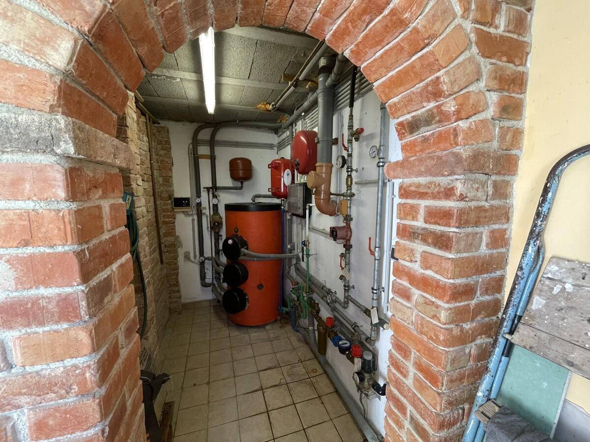 Heizungsraum im Keller mit Ziegelgewölbe und Heizungsanlage.