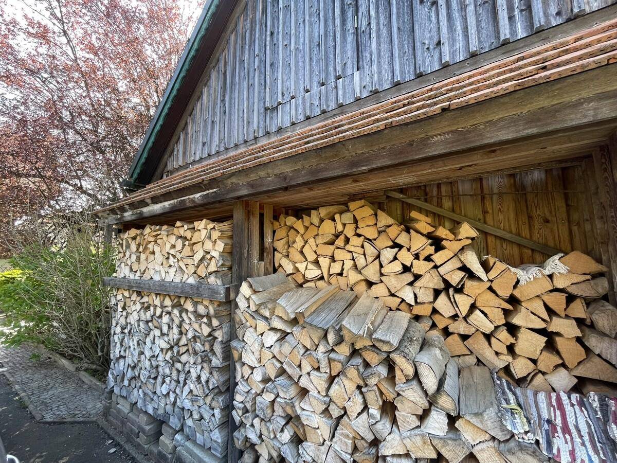 Holzschuppen mit gestapeltem Brennholz, bereit für den Winter.