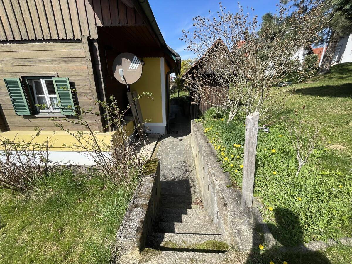Gartenweg mit Treppe zwischen dem Haus und einem Nebengebäude.