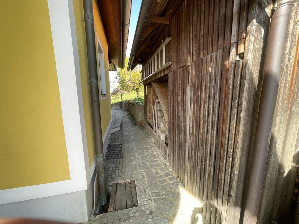Schmaler Durchgang zwischen zwei Gebäuden mit Holzwänden.