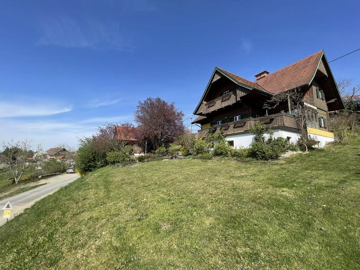 Hausansicht von der Seite mit großem Garten und Blick auf die Landschaft.