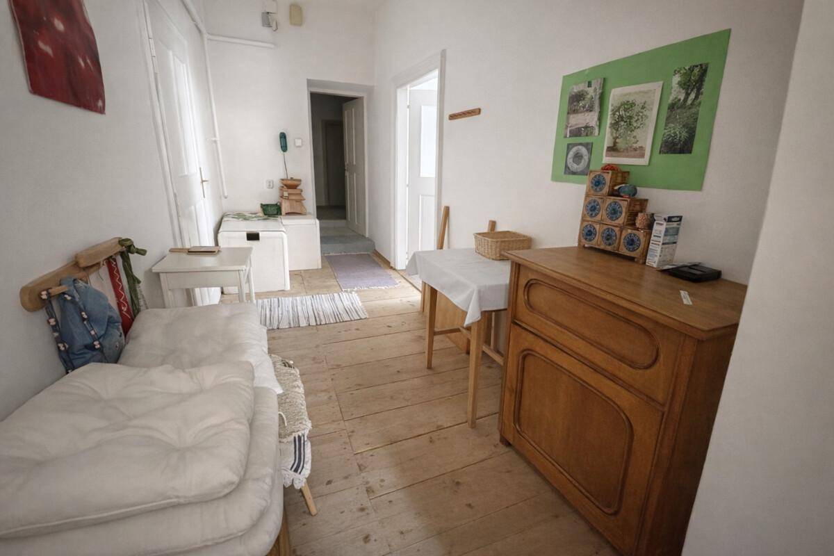 Kleines Schlafzimmer mit Holzdielenboden, Einzelbett und einfacher Einrichtung.