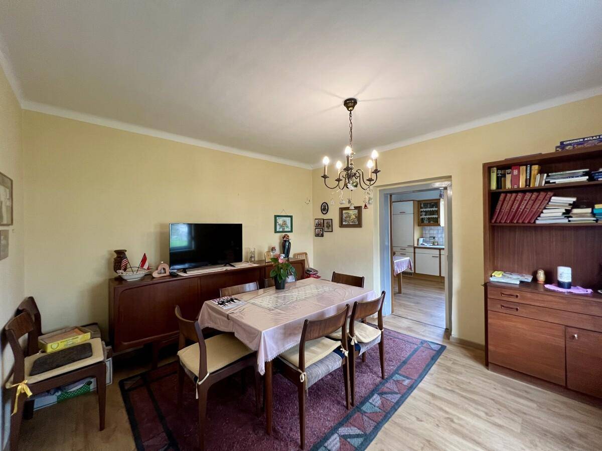 Gemütlicher Essbereich mit Holztisch, Stühlen, Sideboard und Blick in die angrenzende Küche.