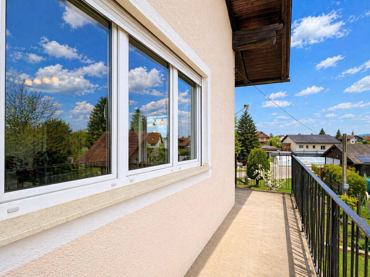 Balkon mit Blick auf die Umgebung und Fenster, die viel Licht in die Innenräume lassen.