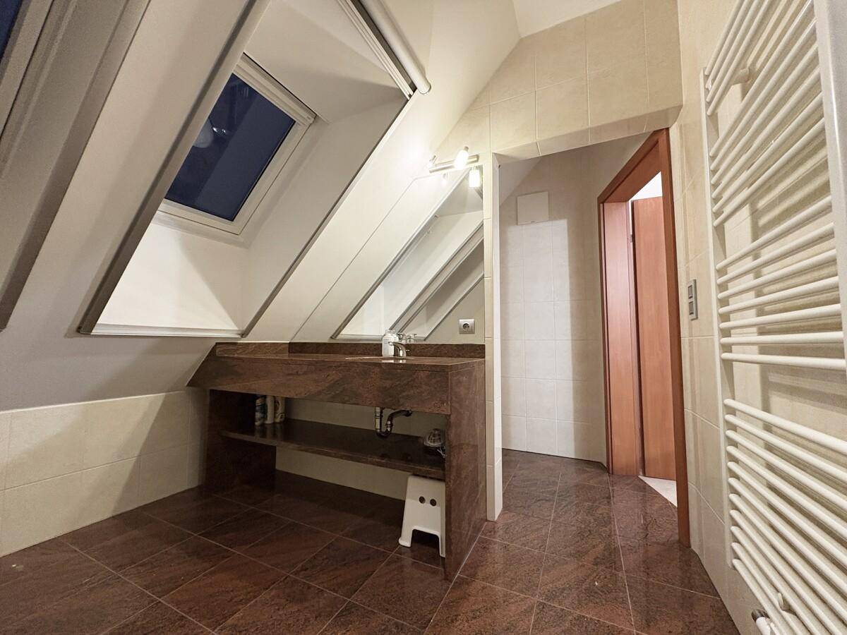 Badezimmer mit Dachfenster, modernem Waschtisch und beheiztem Handtuchhalter.
