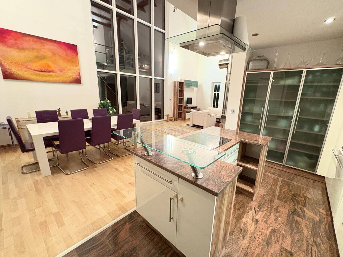 Geräumige offene Küche mit Kochinsel, Granitarbeitsplatten und Essbereich, verbunden mit dem Wohnzimmer.