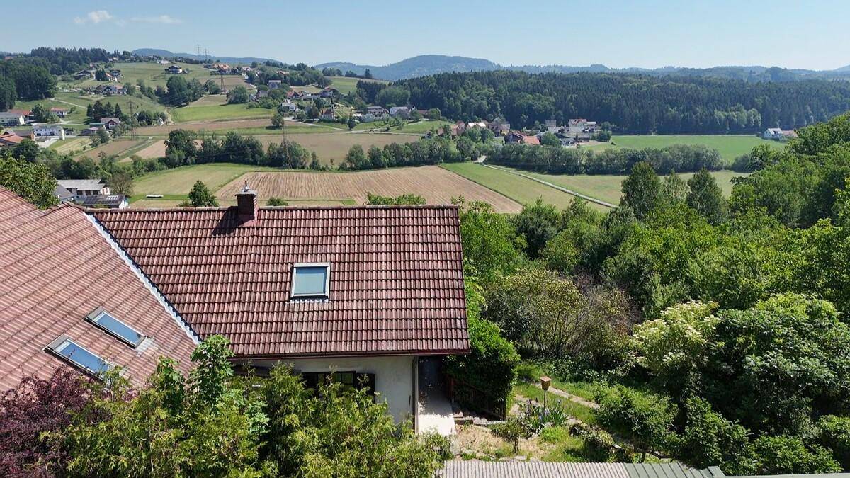 Weitläufige Luftaufnahme eines Hauses mit rotem Ziegeldach und weitem Blick über die ländliche Umgebung.