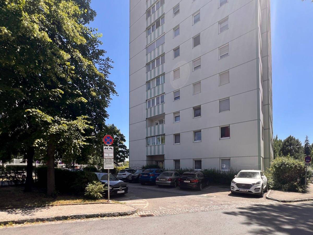 Unterer Bereich des Wohngebäudes mit Parkplätzen und einer Zufahrtsrampe für Fahrzeuge.