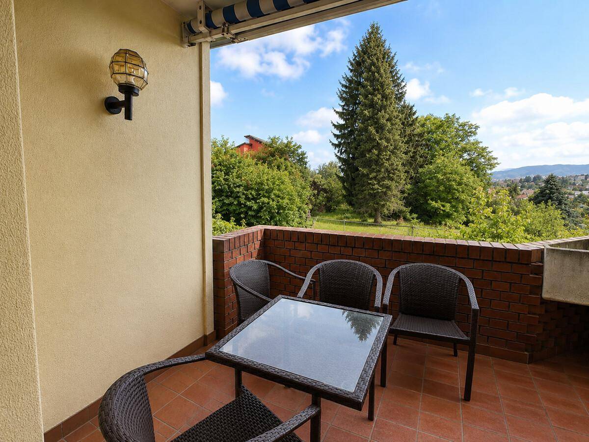 Gemütlicher Balkon mit Sitzgelegenheiten und weitem Blick ins Grüne.