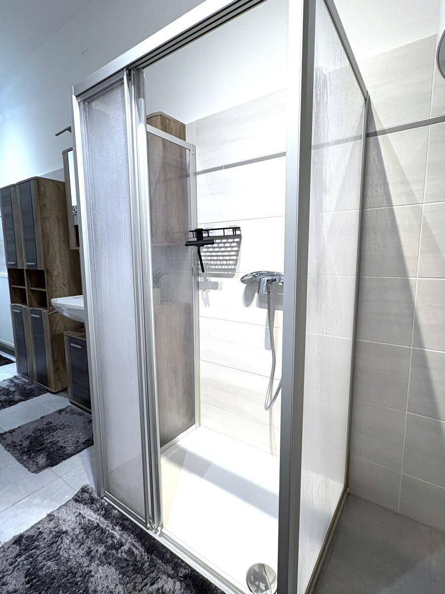 Geräumige Duschkabine mit Glasschiebetür in einem modernen Badezimmer.