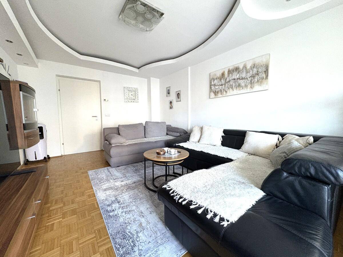 Heller Wohnbereich mit bequemen Sofas, Couchtisch und Parkettboden, ideal zum Entspannen.