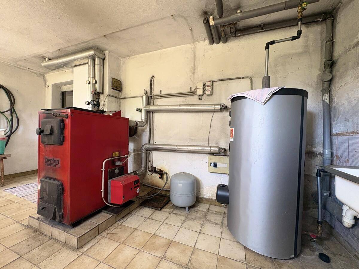 Heizungsraum mit großem Boiler und umfangreicher Rohrinstallation.